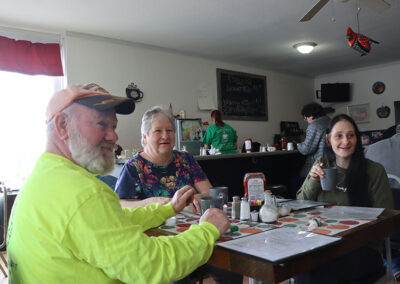 Family smiling while eating breakfast and drinking coffee