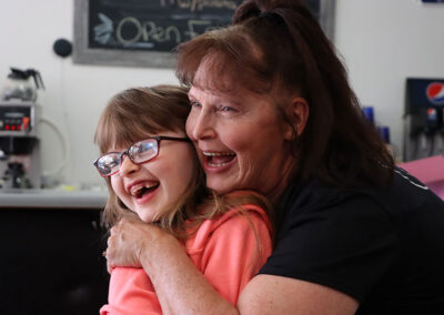 Jill laughing with young girl at Sullivans Diner in Hudson Falls